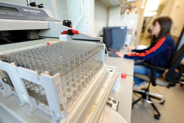 Student in lab with test tube experiment in foreground